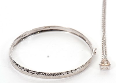 Lot 247 - A 9ct white gold bangle, with diamond cut...