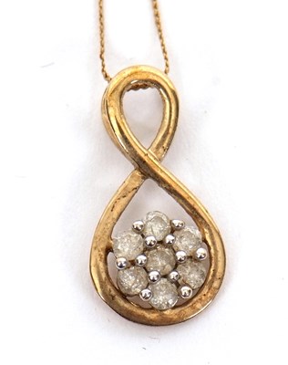 Lot 191 - A 10K diamond pendant necklace, the figure of...