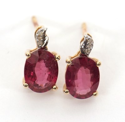 Lot 210 - A pair of 10K garnet and diamond earstuds, the...