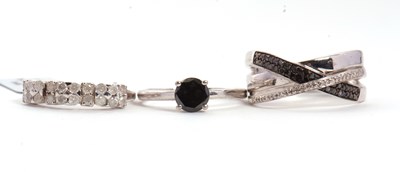 Lot 112 - Three silver and black and white diamond rings:...