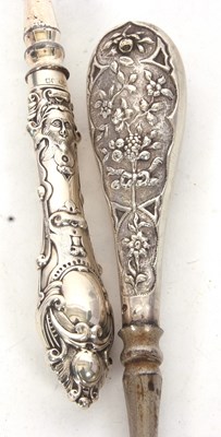 Lot 244 - Two long silver handled and steel button hooks,...