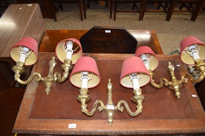 Lot 374 - Set of three brass wall sconces with red shades