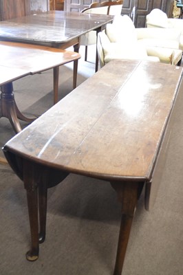 Lot 517 - A large Georgian oval oak drop leaf dining...