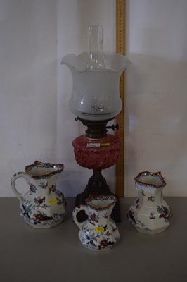 Lot 152 - A late 19th Century oil lamp with cranberry...