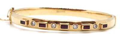 Lot 104 - A 9ct ruby and diamond bangle, the hinged...