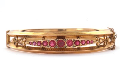 Lot 132 - A 9ct ruby bangle, the hinged bangle set with...