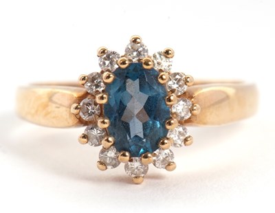 Lot 21 - A 9ct topaz and diamond cluster ring, the oval...