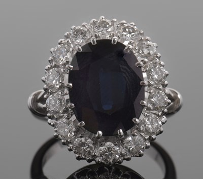 Lot 415 - A sapphire and diamond cluster ring, the oval...