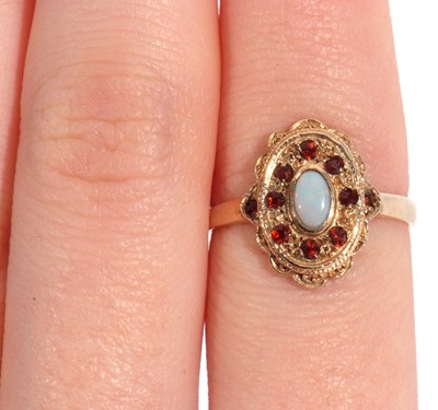 Lot 50 - 9ct gold opal and red stone ring, the cabochon...