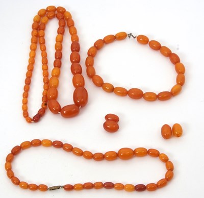 Lot 184 - Three amber bead necklaces, the graduated oval...