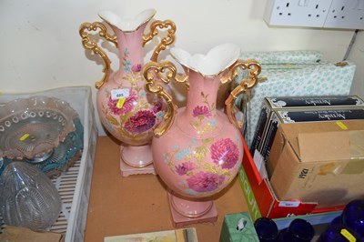 Lot 685 - A pair of pink floral and gilt decorated vases