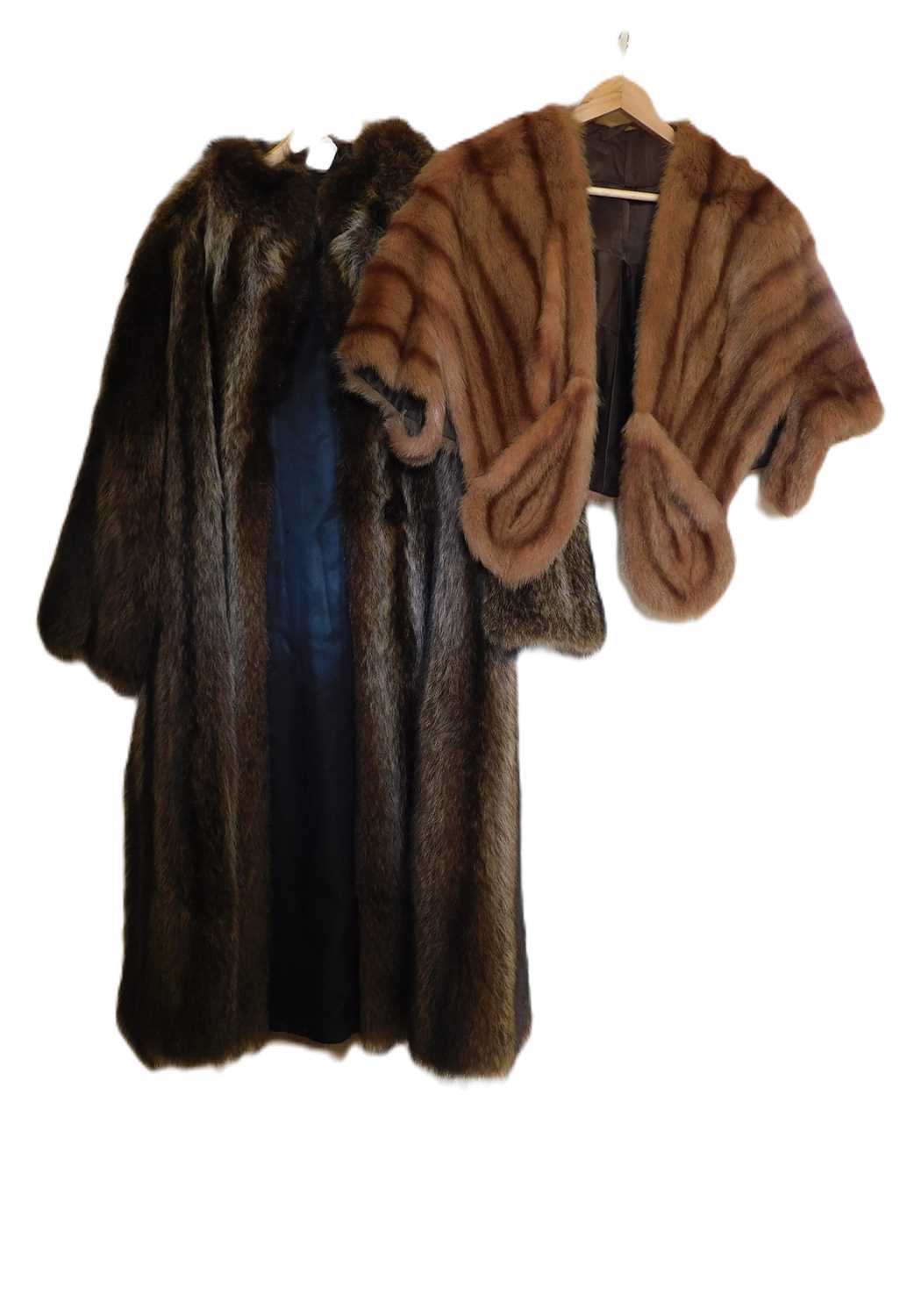 Lot 100 - A short fur cape with front pockets/hand...