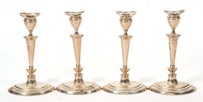 Lot 317 - A set of four Edwardian silver candlesticks in...