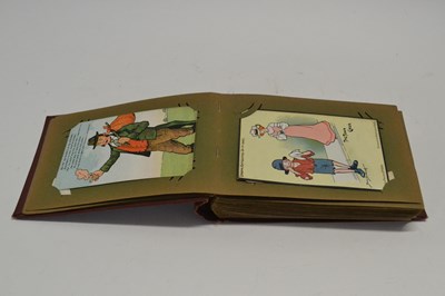 Lot 556 - A postcard album mainly with humerous cards,...