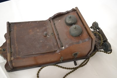 Lot 596 - An antique wall mounted telephone in wooden...