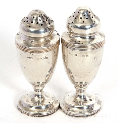 Lot 113 - A pair of George V silver peppers of urn form...