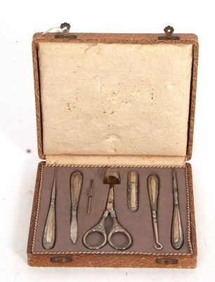 Lot 147 - A cased travelling sewing set with white metal...