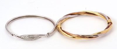 Lot 168 - Two bangles: one tri-colour bangle stamped 9K,...