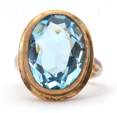 Lot 57 - A silver-gilt blue stone ring, the oval...