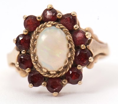 Lot 53 - A 9ct opal and garnet ring, the central oval...