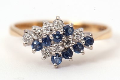 Lot 59 - An 18ct sapphire and diamond ring, set with...