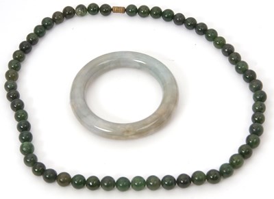 Lot 192 - A jade bangle and nephrite necklace, the jade...