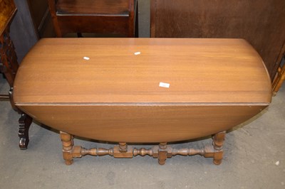 Lot 783 - An Ercol oval drop leaf coffee table on turned...