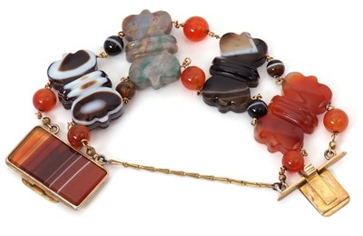 Lot 165 - An agate bracelet, the carved bowtie shape...