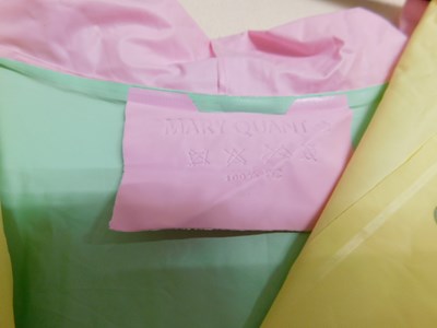 Lot 61 - A Mary Quant PVC hooded rain poncho, in pastel...