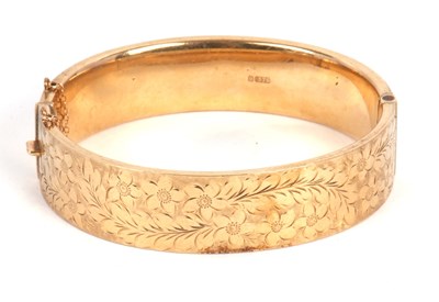 Lot 206 - A 9ct gold bangle, with engraved floral...