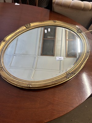 Lot 627 - An oval bevelled wall mirror