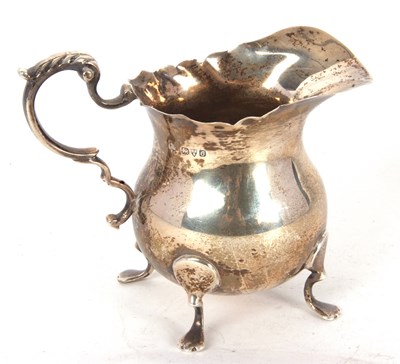 Lot 77 - A George V silver cream jug of plain baluster...