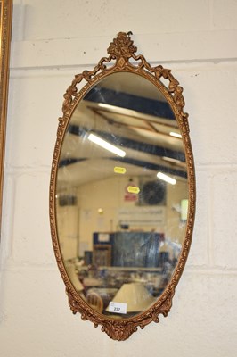 Lot 237 - A 20th Century wall mirror in oval cast metal...