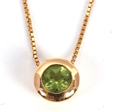 Lot 130 - An 18ct peridot necklace, the round peridot in...