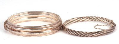 Lot 232 - Two silver bangles: to include a hinged...