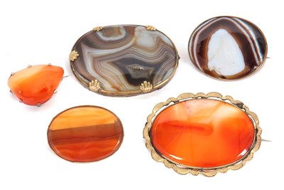 Lot 266 - Five agate brooches, to include an oval banded...