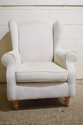 Lot 281 - A cream upholstered wing back armchair