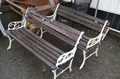 Lot 833 - A pair of hardwood and iron ended garden benches