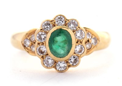 Lot 32 - An 18ct emerald and diamond ring, the oval...