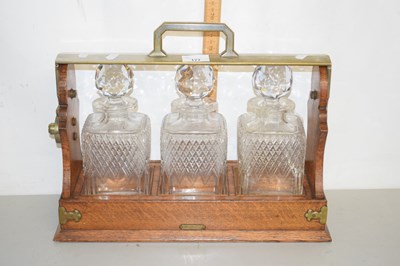 Lot 177 - An oak framed three bottle tantalus marked...