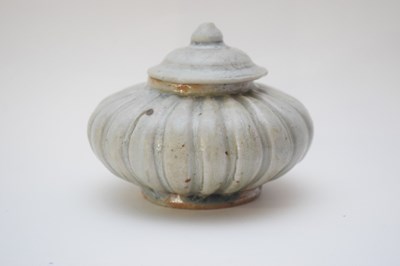 Lot 10 - Small pottery jar and cover of compressed form...