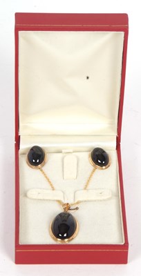 Lot 131 - An onyx pendant and earrings, the oval black...