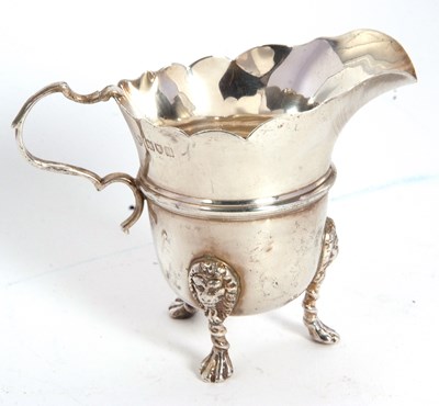 Lot 25 - A George V silver cream jug having a card cut...