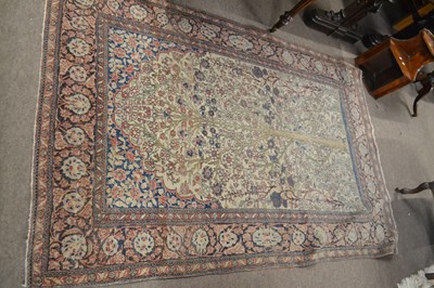 Lot 660 - A worn Persian wool rug decorated with central...