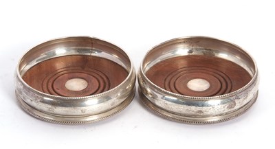 Lot 13 - A pair of silver framed large bottle coasters...