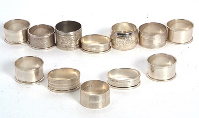 Lot 89 - A group of eleven silver serviette rings,...