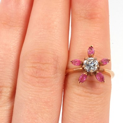 Lot 25 - A pink sapphire and CZ ring, the central round...