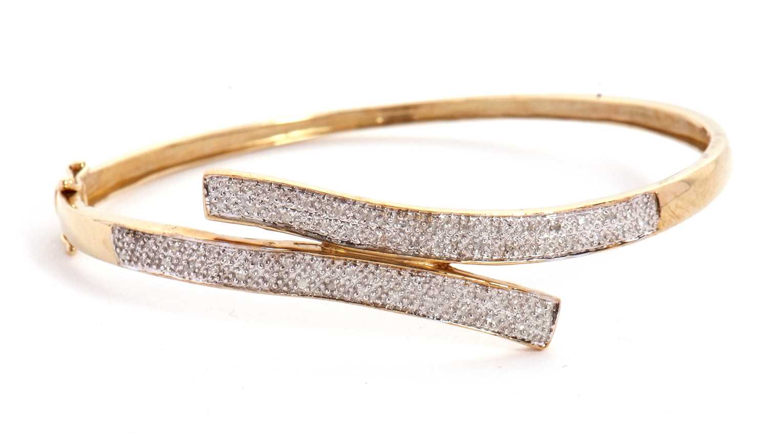 Lot 101 - A diamond bangle, the hinged crossover style...