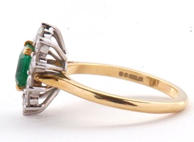 Lot 74 - An 18ct emerald and diamond ring, the central...