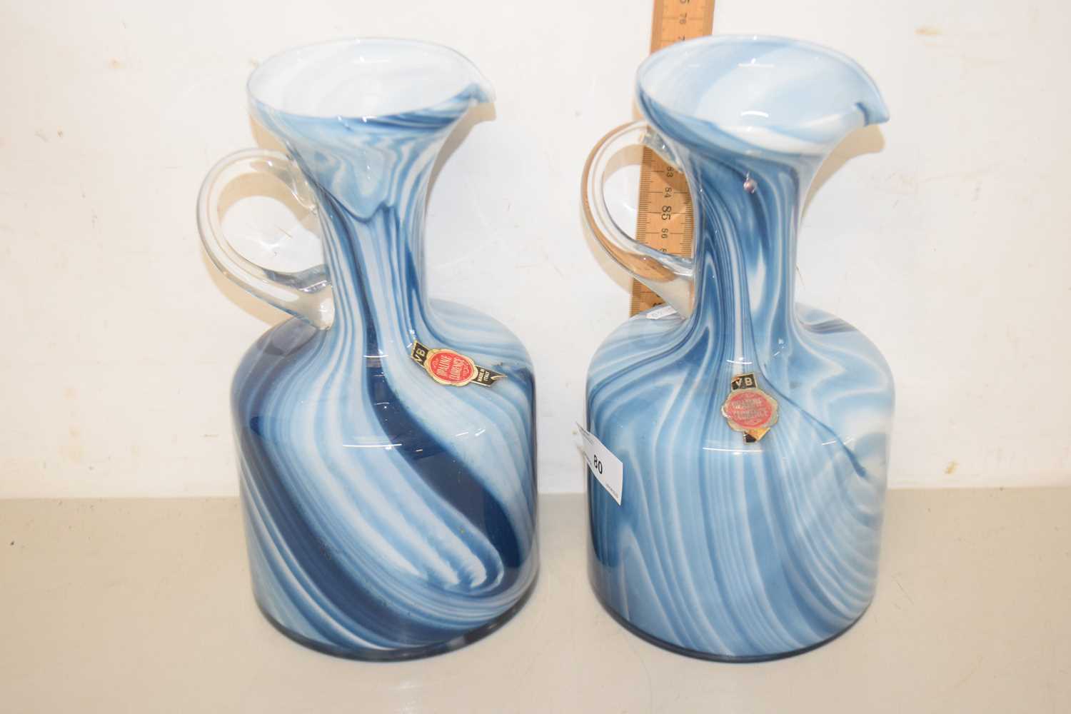Lot 80 - A pair of blue swirled Art Glass jugs bearing...